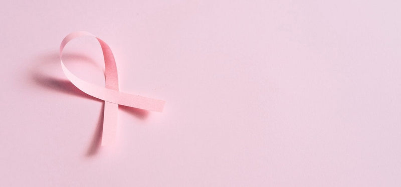 Pink breast cancer awareness ribbon on a solid pink background.
