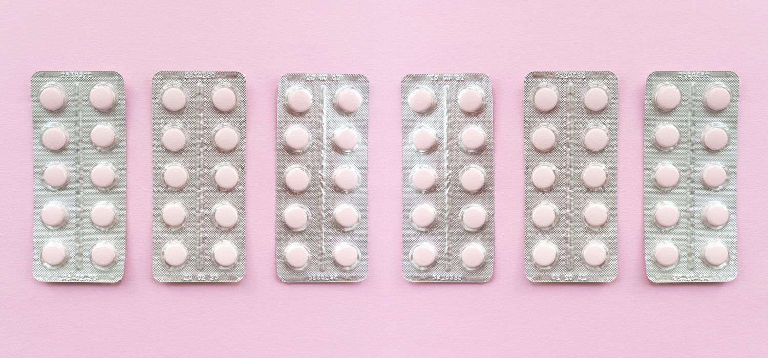 A line of Fluconazole blisters on a pink background.