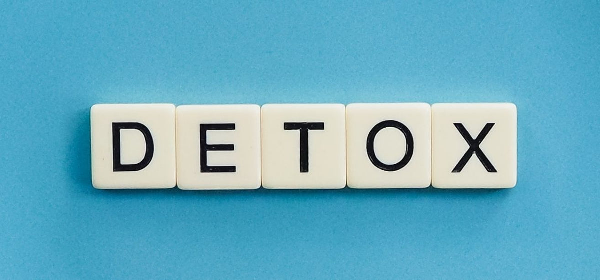 White letter tiles spelling DETOX on a blue background, illustrating natural body detoxification.