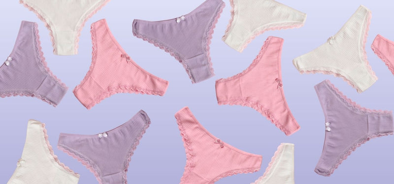 An image of multiple pairs of women's underwear in pink, purple and white, on a periwinkle background.