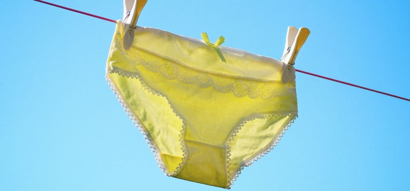 Yellow underwear hanging on a clothesline against a blue sky.