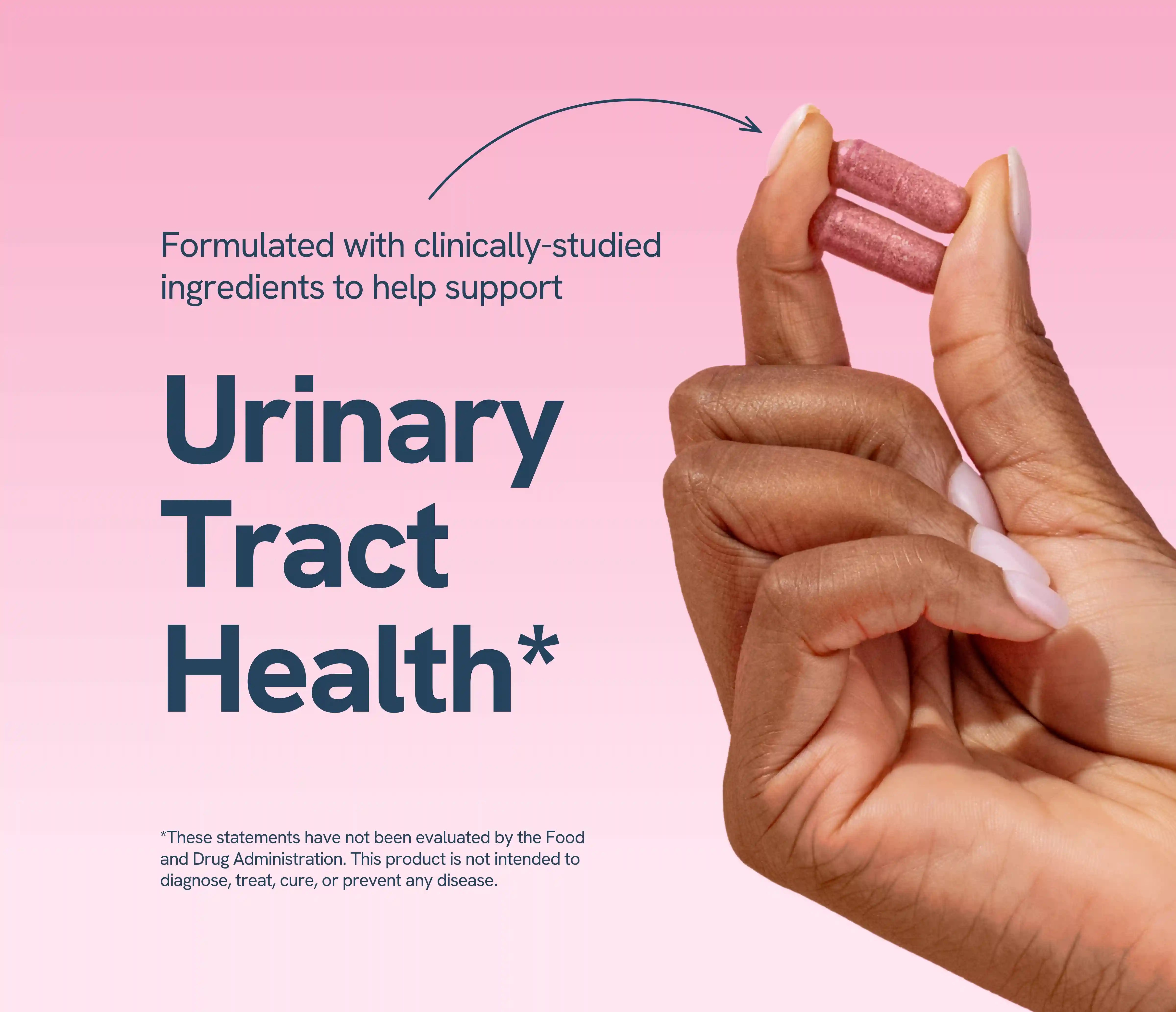 Hand holding two capsules with text about urinary tract health on pink background.