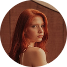 A woman with red hair holds a Happy V supplement bottle, promoting feminine wellness.