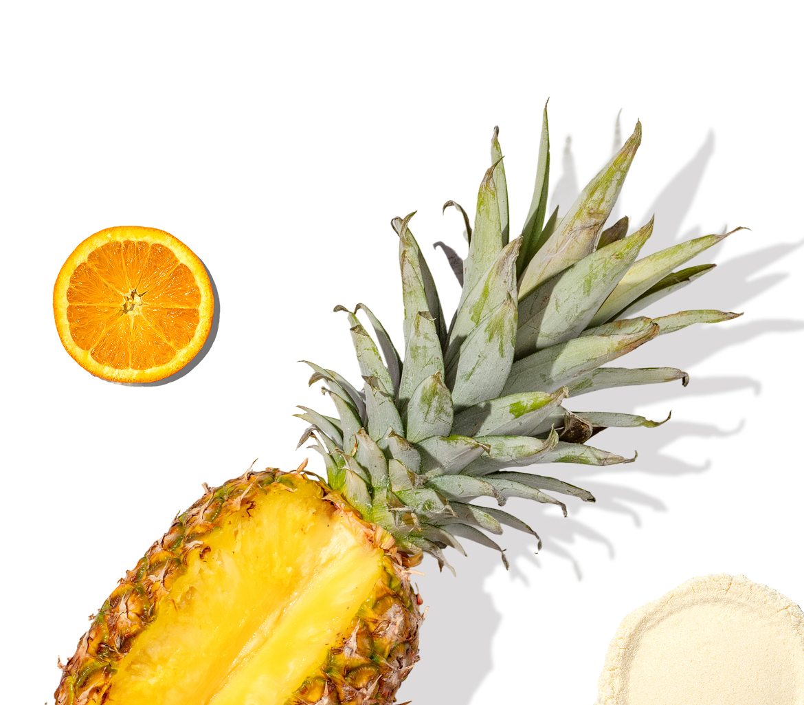 Pineapple half, orange slice, and Happy V supplement powder on a sleek black background.