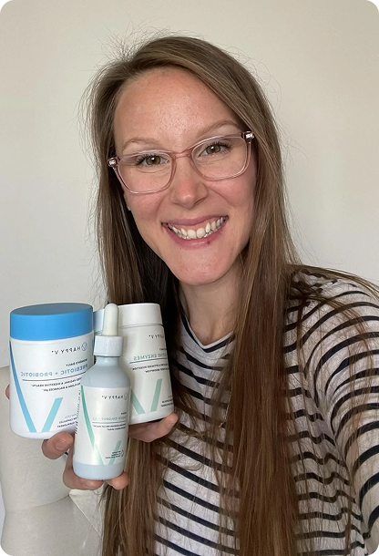 Woman holding Happy V products including supplements for women's health and wellness.