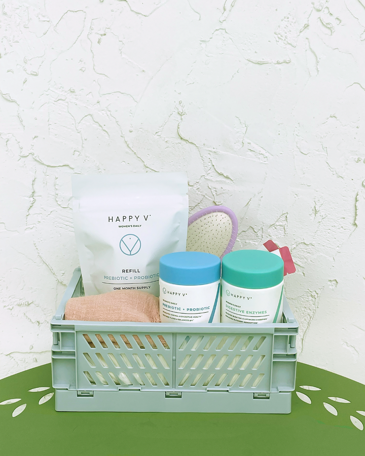 A teal plastic basket filled with a collection of Happy V products