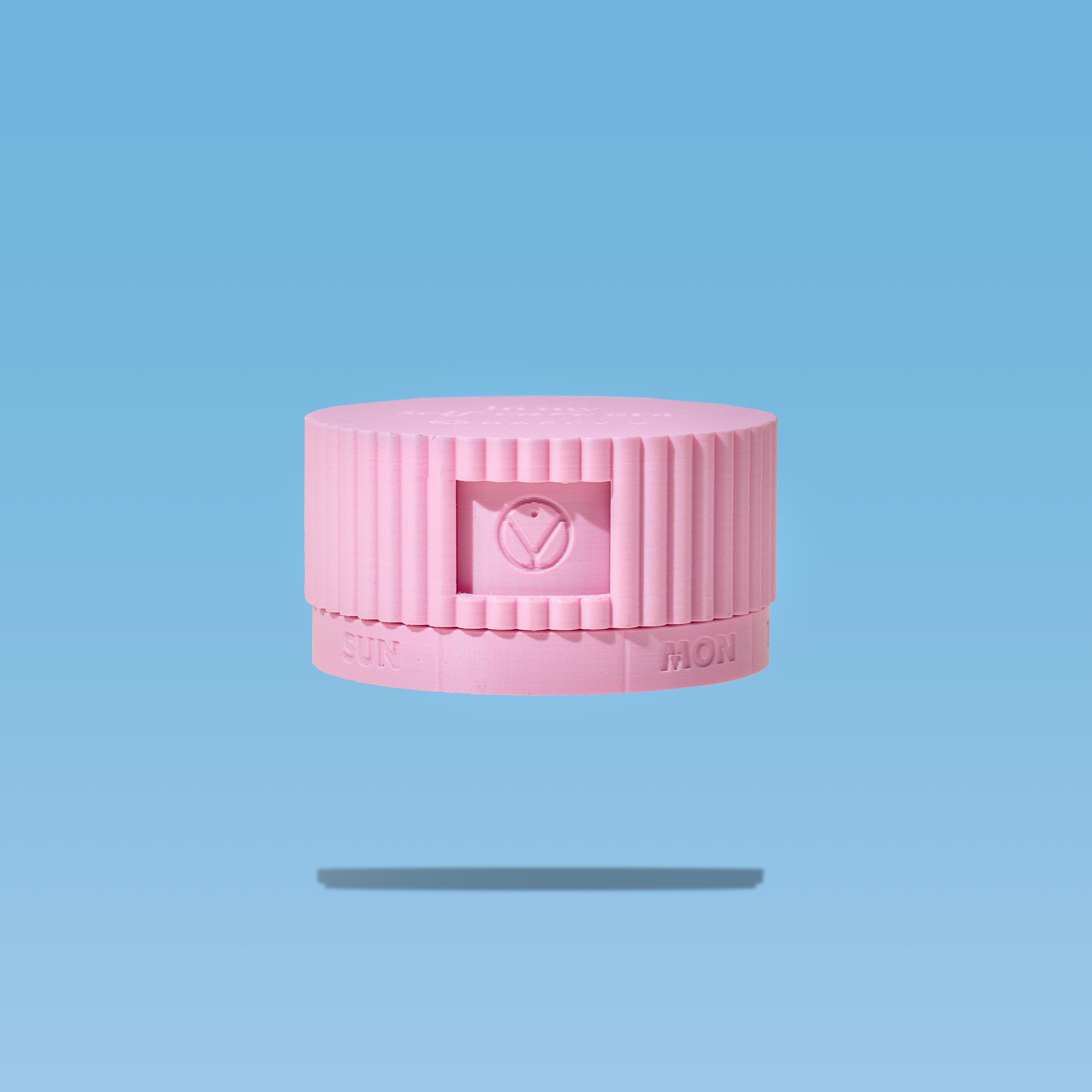 Pink pill organizer with Happy V logo on a blue background, emphasizing feminine wellness.