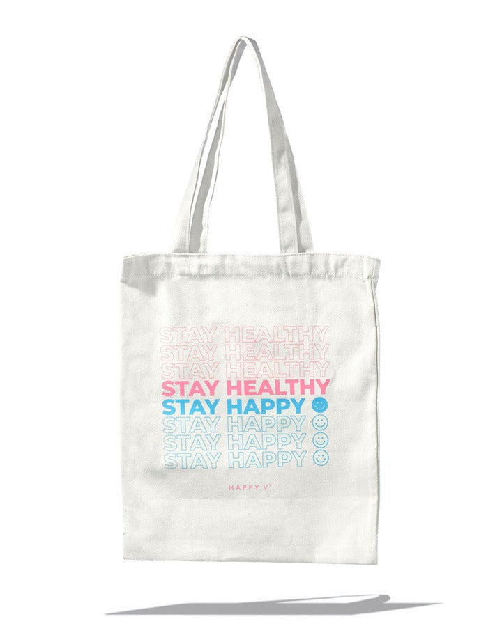 White tote bag with "Stay Healthy Stay Happy" text, promoting Happy V's wellness philosophy.