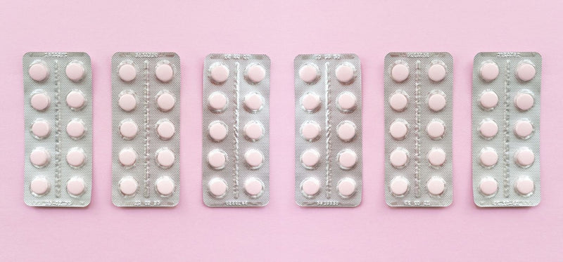 A line of Fluconazole blisters on a pink background.