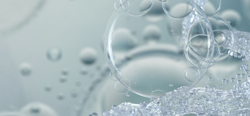A macro image of hydrogen peroxide bubbles on a grey background.