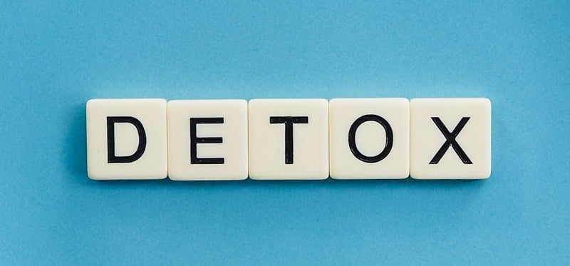 White letter tiles spelling DETOX on a blue background, illustrating natural body detoxification.