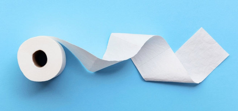 Unrolled white toilet paper on a blue background.
