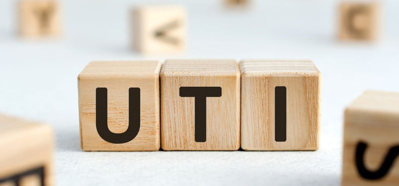 Wooden blocks spelling UTI on a white surface with scattered blocks in the background, illustrating urinary tract infections.