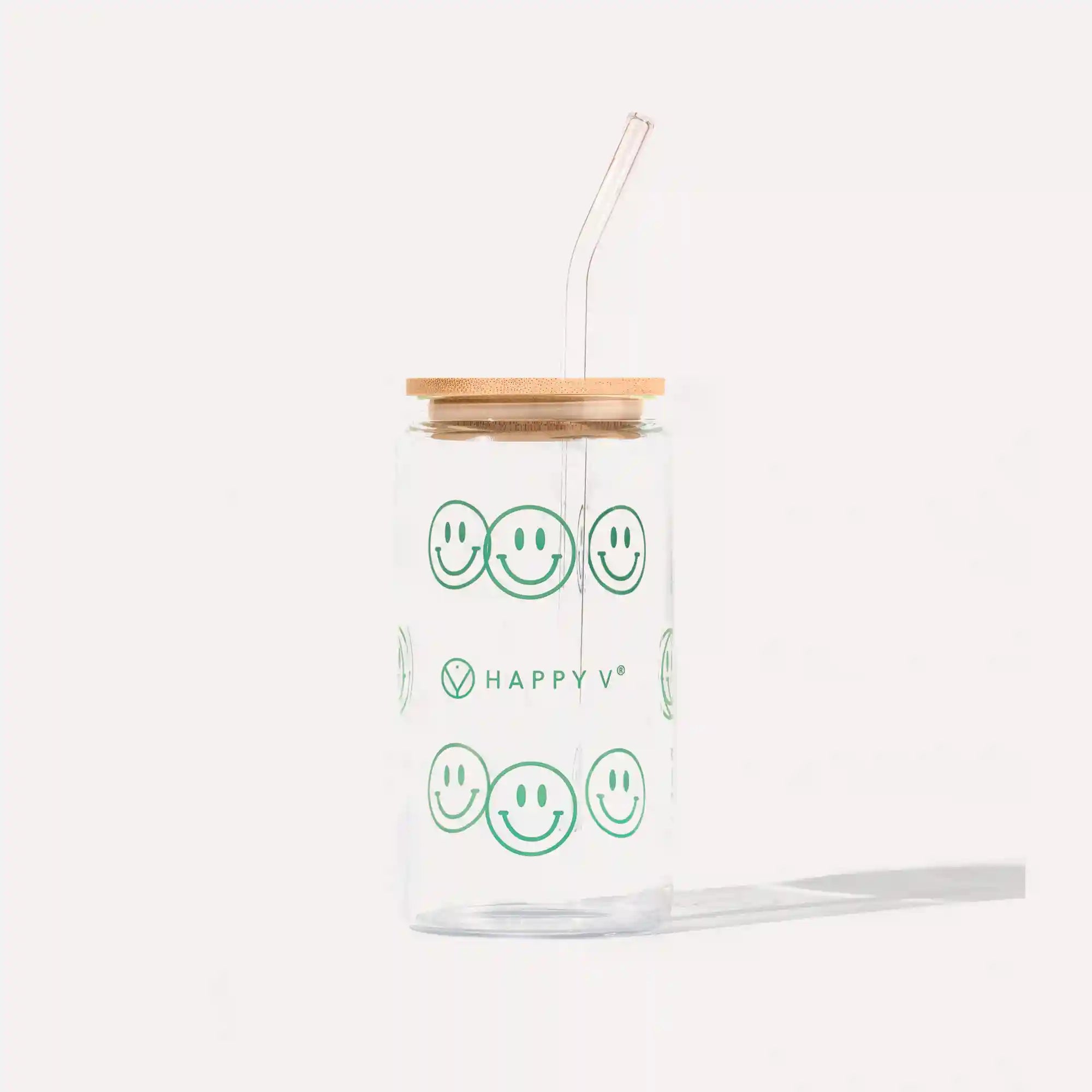 Clear glass jar with green smiley faces, wooden lid, and straw, reflecting Happy V's cheerful branding.
