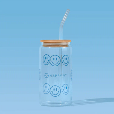 Glass tumbler with smiley faces and a straw, symbolizing Happy V's joyful wellness approach.
