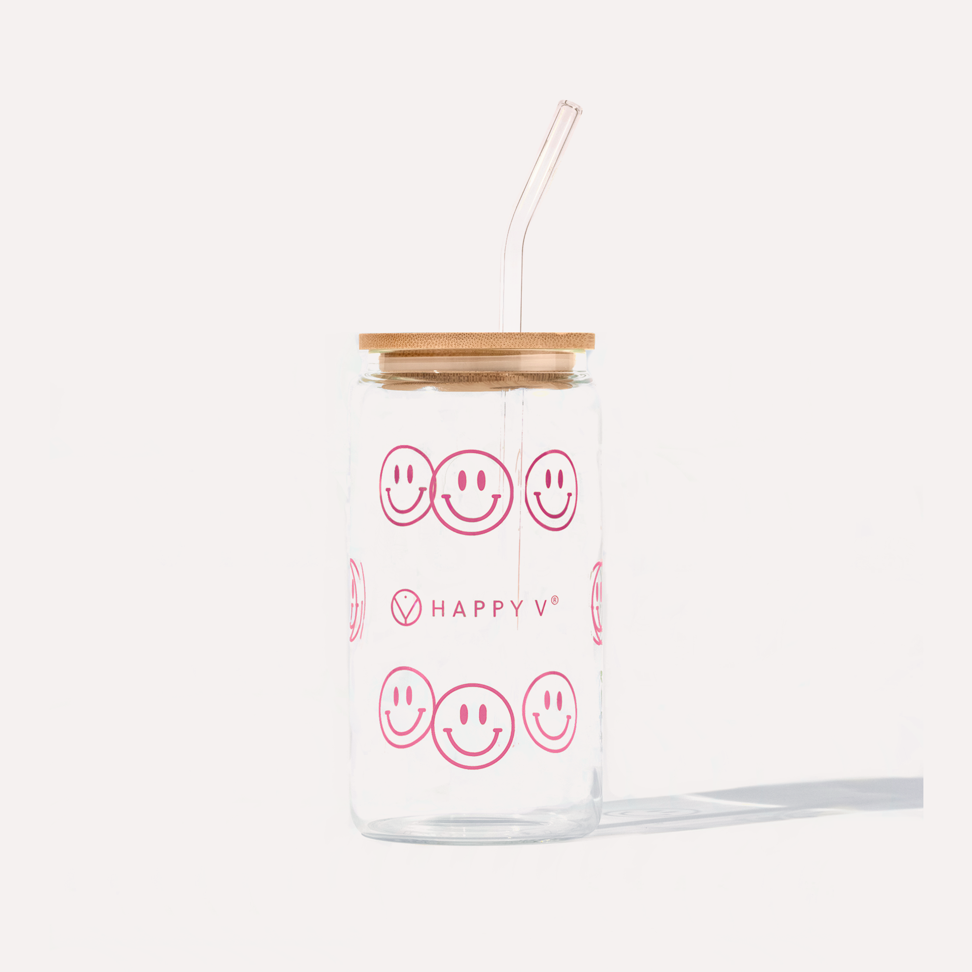 Clear glass cup featuring Happy V's signature pink smiley faces and a sleek straw.