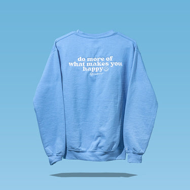 Blue sweatshirt saying “do more of what makes you happy,” reflecting wellness.