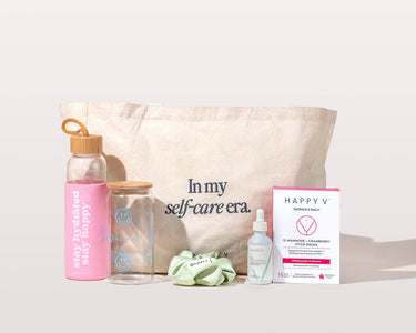 Tote with self-care items including Happy V supplements and a pink water bottle.
