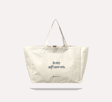 Canvas tote with "In my self-care era" text, promoting Happy V's wellness focus.