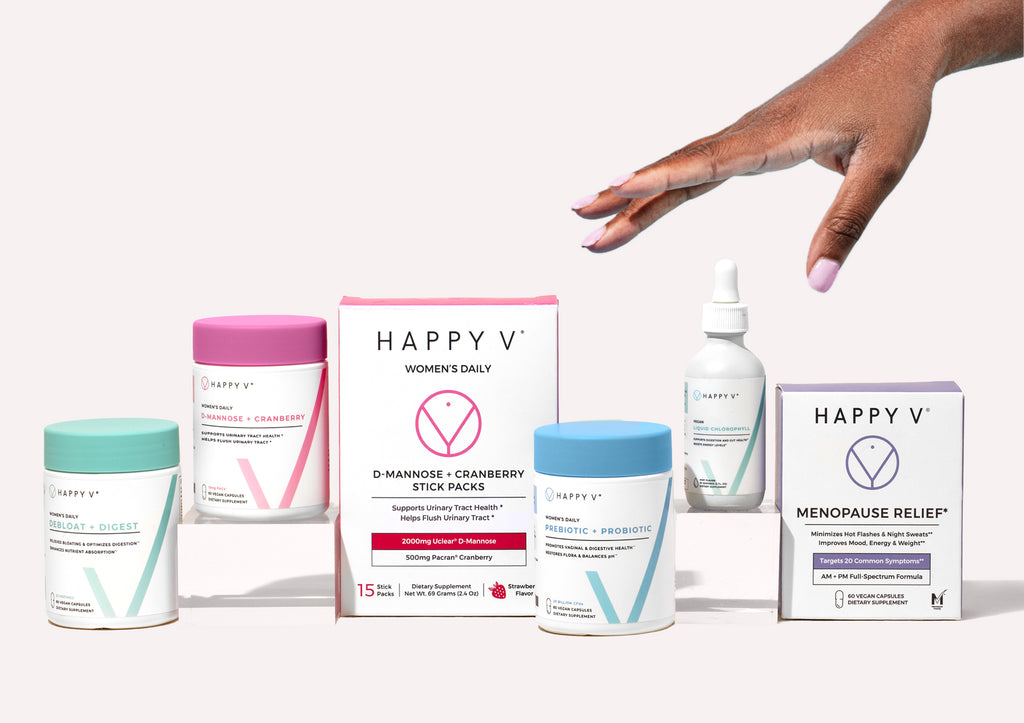 Hand reaching over Happy V supplement collection for women's wellness.