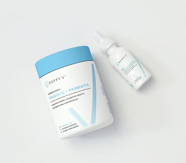 A bottle of Happy V Prebiotic and Probiotic Supplements bottle with a Happy V Liquid Chlorophyll bottle.